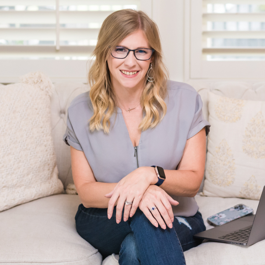 Jennifer Stalley, a woman in glasses, sitting on a couch with a laptop.