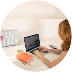 A woman working on a laptop at a desk.