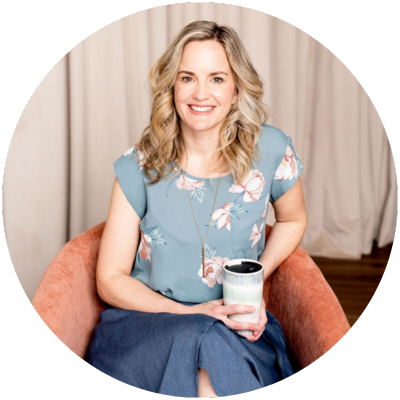 A woman sitting in an orange chair with a cup of coffee.