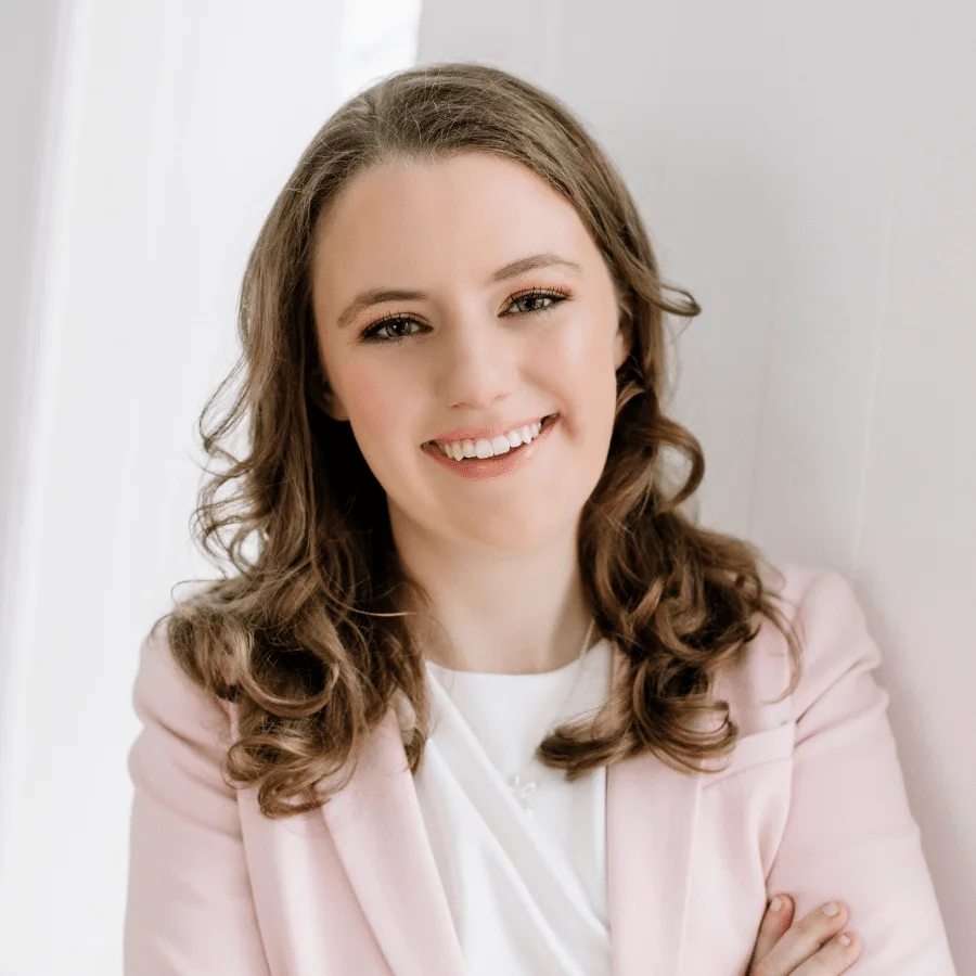 Clare Lewis, a smiling woman in a pink blazer.