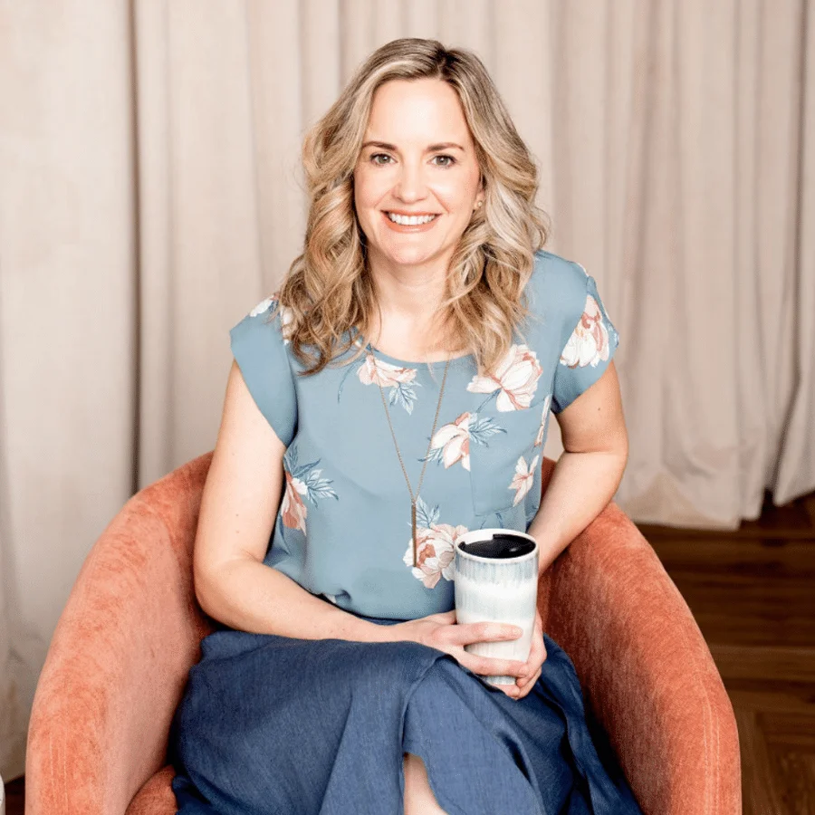 Nicole Kepic sitting in a chair holding a cup of coffee.