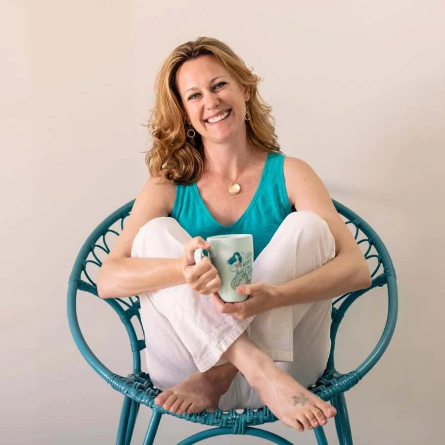 January 2024 income report feature image A woman sitting in a blue chair holding a mug.
